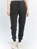 A pair of gray cuffed cashmere joggers displayed on a model without showing the upper part of the body. #color_charcoal