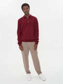 front view of a man wearing A red cashmere polo sweater with a collar, buttons, and long sleeves, beige pants on a light gray background #color_bordeaux