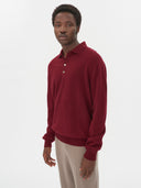 close up front view of a man wearing A red cashmere polo sweater with a collar, buttons, and long sleeves, beige pants on a light gray background #color_bordeaux