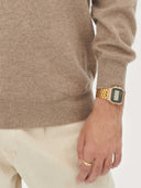 close up of a beige sweater sleeve, white pants, hand-watch worn by a man #color_taupe