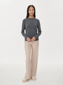 front view of a woman wearing a gray crew neck sweater, beige pants and boots on a white background #color_stone-gray