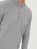 close up front view of a man wearing a gray quarter zip cardigan on a light gray background.  #color_vapor-blue