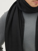 close up of a man wearing a black scarf and a gray sweater