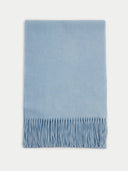 flat lay of a light blue fringed scarf on a light gray background  #color_light-blue