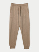 A pair of beige cashmere men's joggers with ribbed trims and an adjustable waistband drawstring. #color_taupe