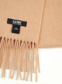 close up of an almond color fringed scarf with label "GOBI","100% cashmere"  #color_toasted-almond